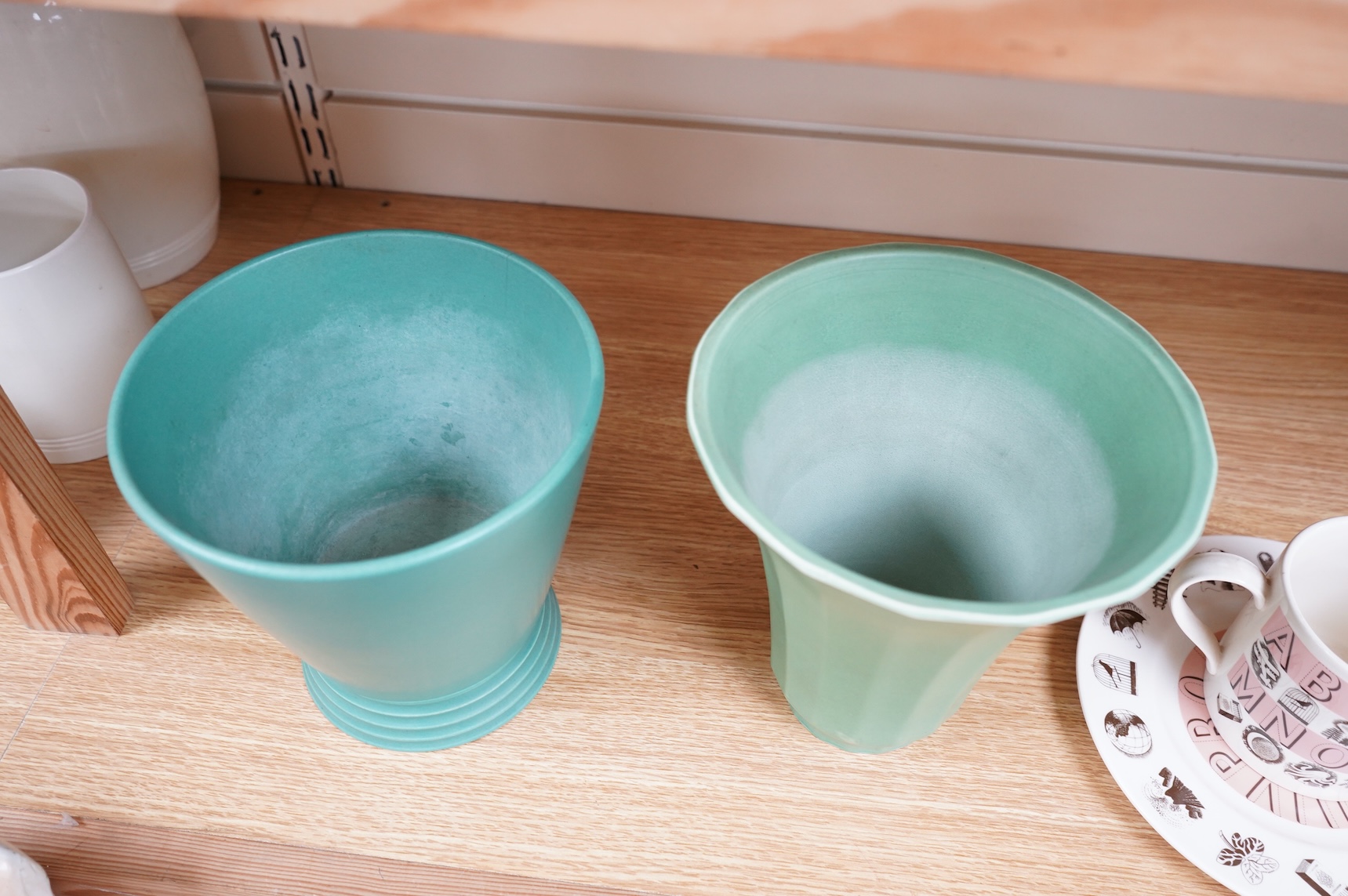 Keith Murray for Wedgwood, two green vases comprising a tapering, fluted example and one with stepped foot, largest 18cm high
